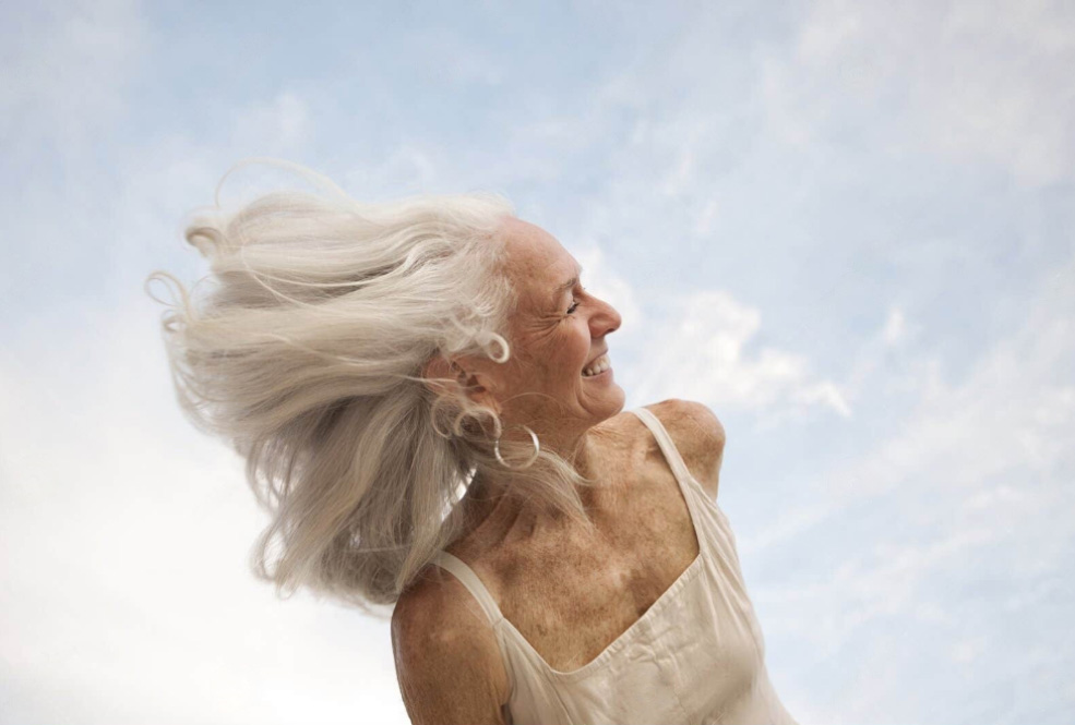 Australian Menopause Centre Happy senior woman portrait with her hair dancing in the wind.