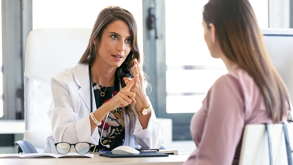 Serious young gynecologist giving guidelines to his patient in the clinic.