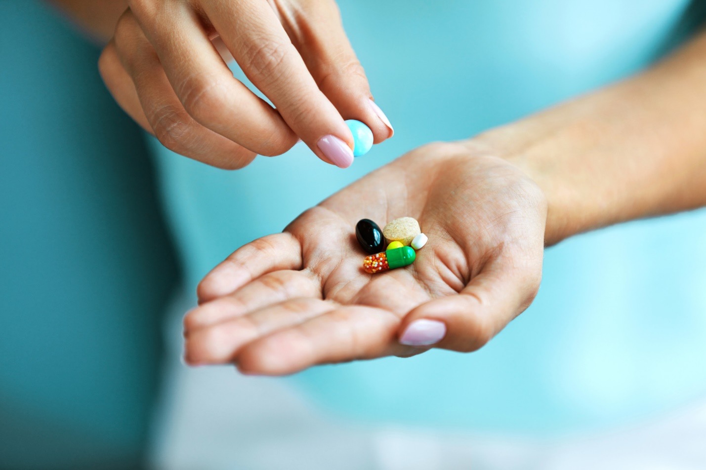 Australian Menopause Centre Vitamins And Supplements. Female Hand Holding Colorful Pills