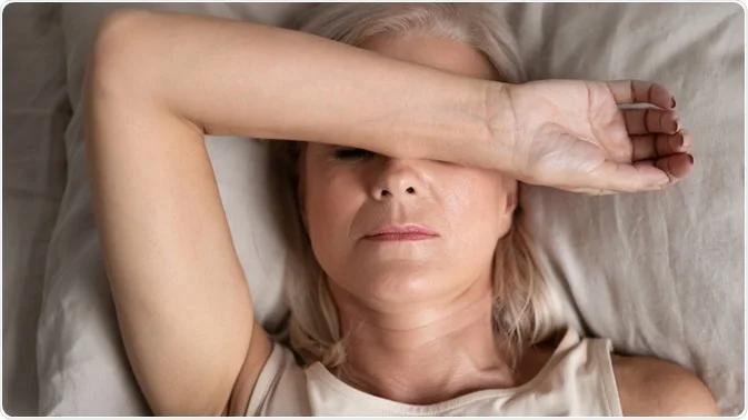 Australian Menopause Centre Closeup melancholic woman lying put hand on face feels unwell - Hormonal Changes Impact Intimacy