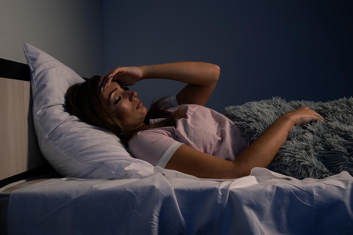 Stressed female insomnia. Young lady lying in the bed and want to sleep