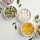 Different vitamin capsules in bowls and leaves on white background, flat lay.