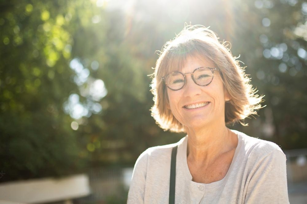 Close up smiling older woman outside with glasses - Women on World Menopause Day 2024